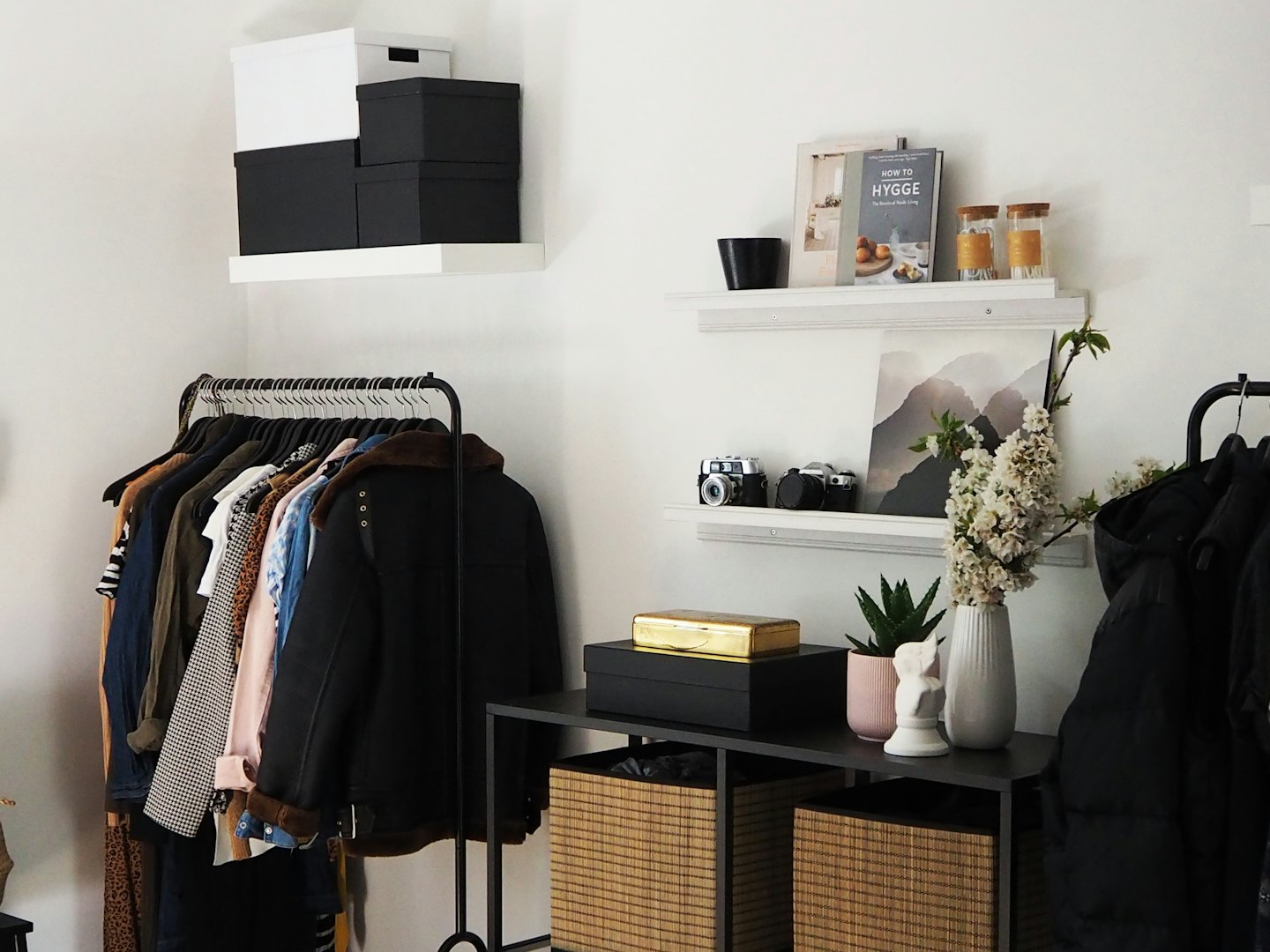 Clothing racks and shelves display apparel and decor in an organized room.