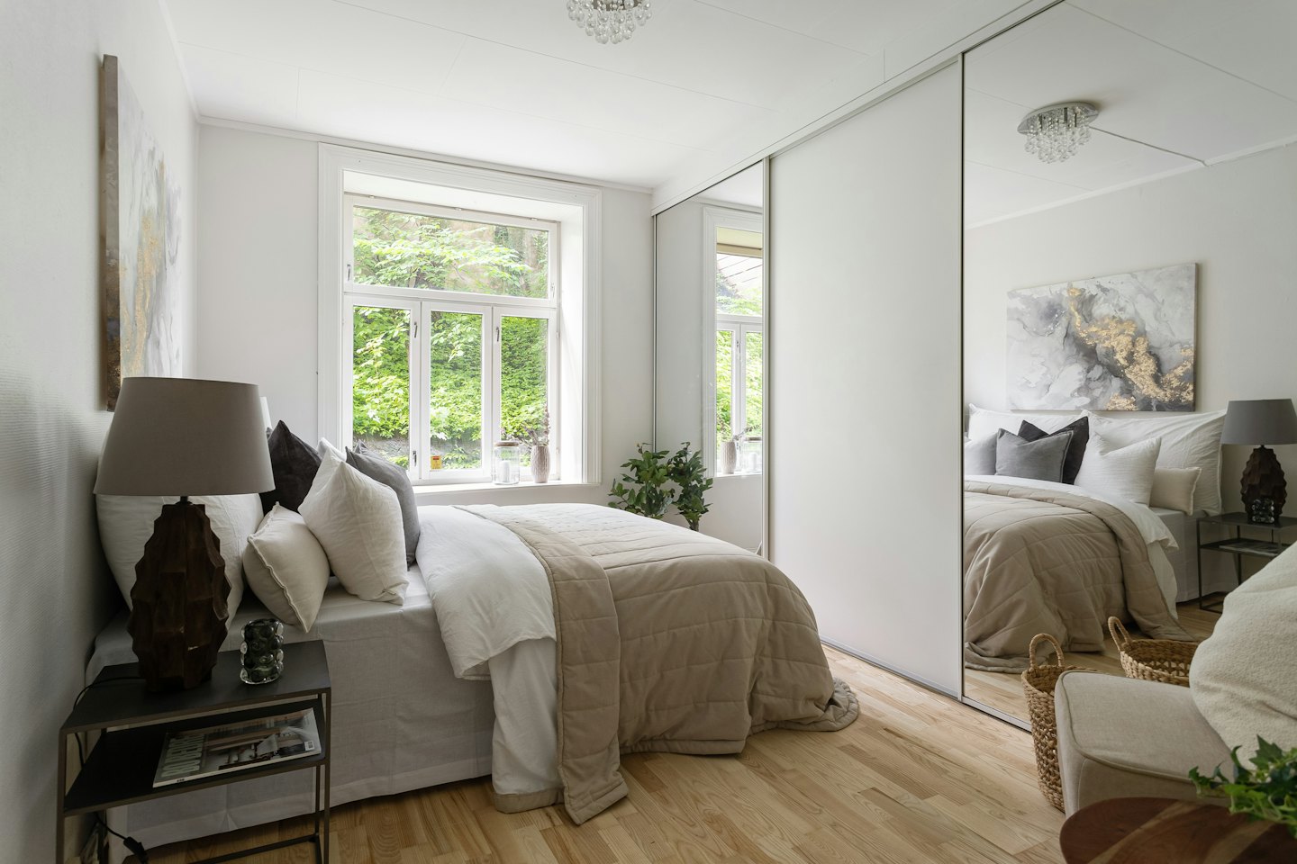 A modern bedroom with a made bed and large window.