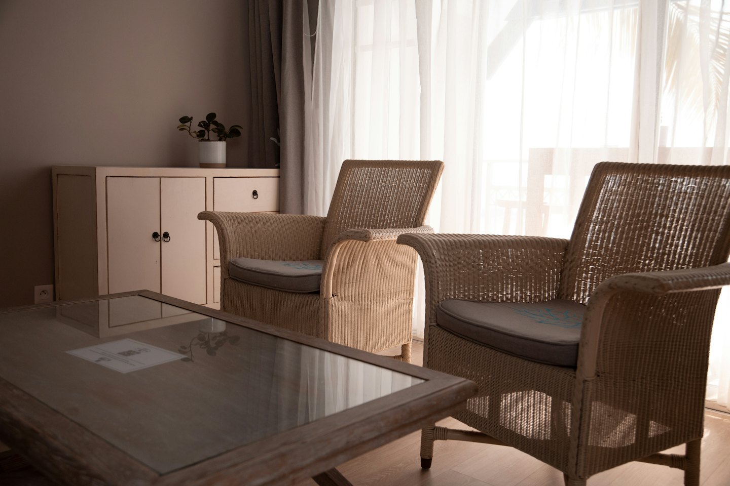 Two wicker armchairs and a wooden coffee table in a living room.
